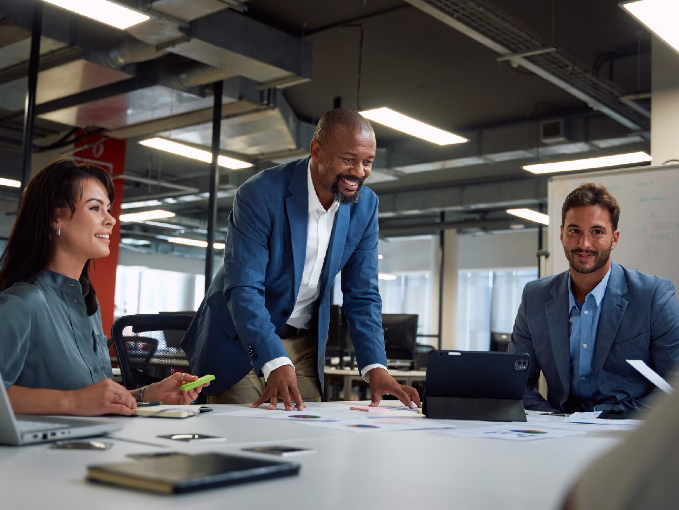Three businesspeople _smiling in a conference room